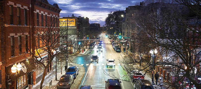 A city street at night with cars driving down the road. Description generated by AI