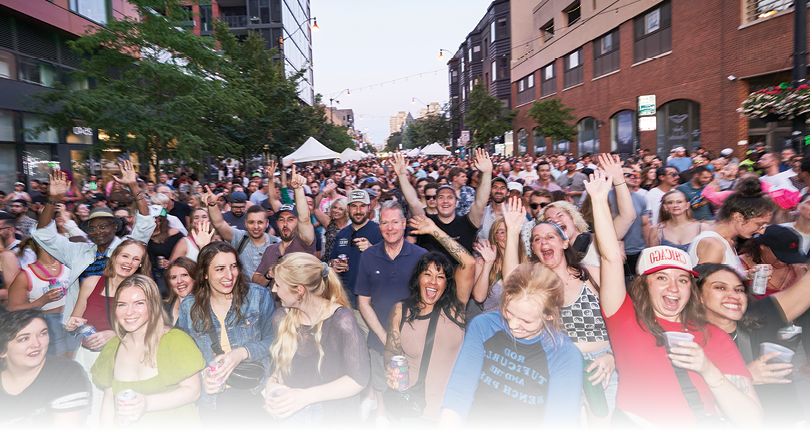 A large group of people are standing on a street, some of them are holding beer cans. Description generated by AI