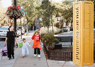 A woman and a child walking on a sidewalk. Description generated by AI