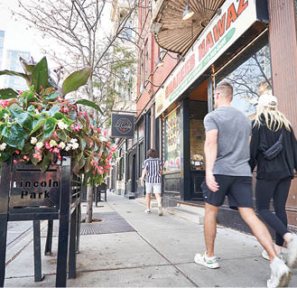 A man and woman walking down a sidewalk. Description generated by AI