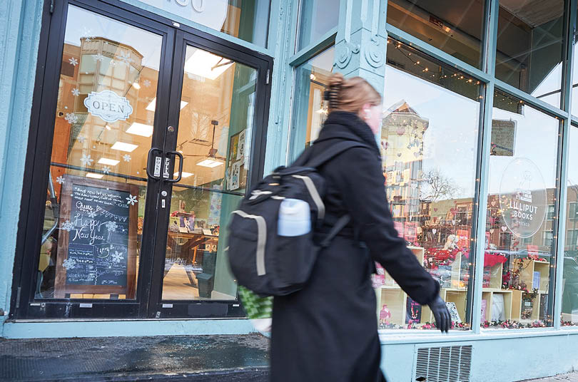 A woman walking on a sidewalk. Description generated by AI
