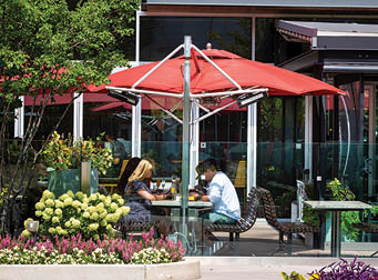 A red and white umbrella is over a table. Description generated by AI