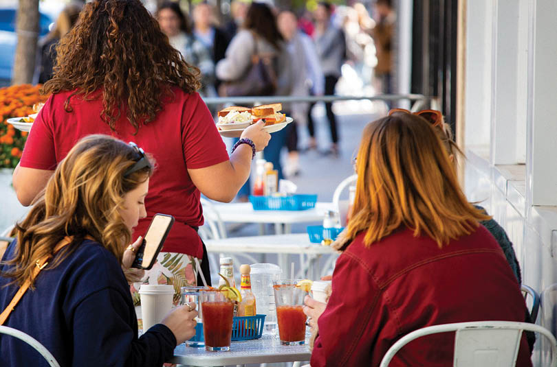 A woman in a red shirt is serving food to a woman in a red shirt. Description generated by AI