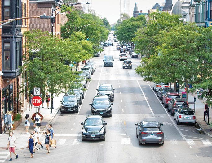 A busy city street with cars and pedestrians. Description generated by AI