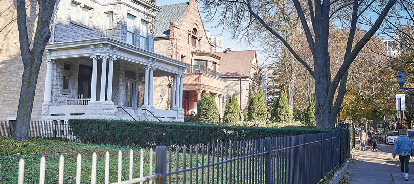 A black iron fence in front of a house. Description generated by AI