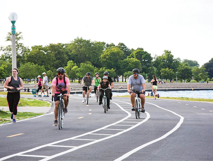 A group of people riding bikes on a path. Description generated by AI