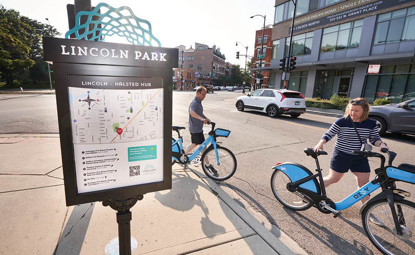 A blue bike is parked on the sidewalk. Description generated by AI
