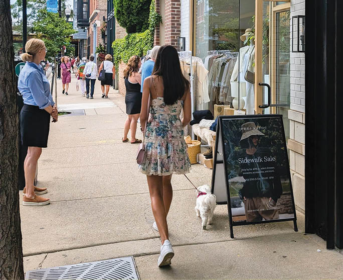 A woman walking on a sidewalk. Description generated by AI