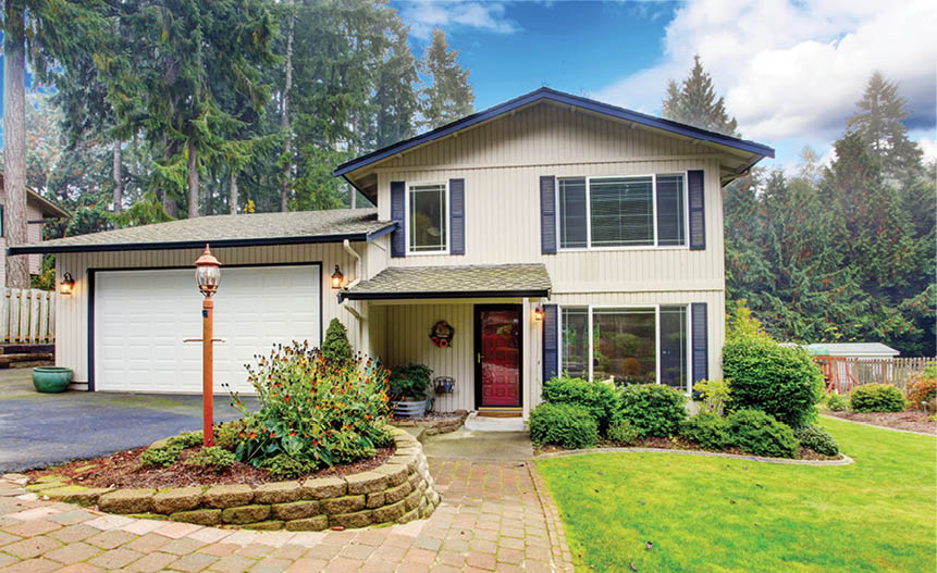 Two story house with garage. View of entrance porch and brick walkway.
