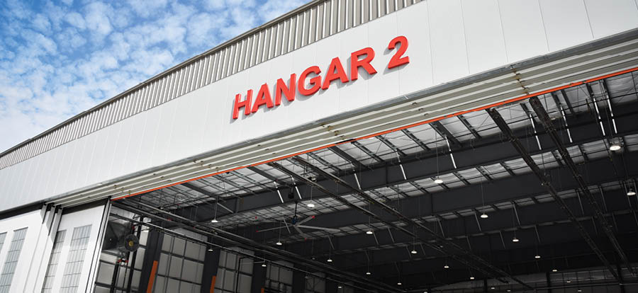 A white building with a red sign that says “hangar 2". AI generated content