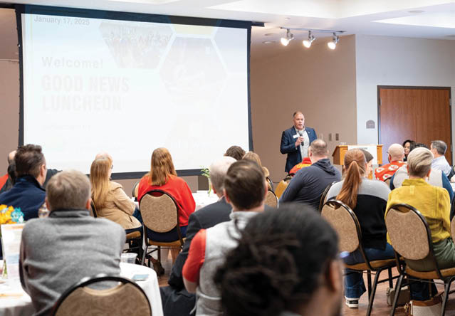 A man is giving a presentation in front of a large group of people. AI generated content