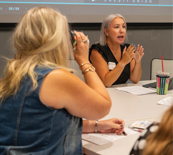 A woman in a black shirt is speaking at a conference. AI generated content