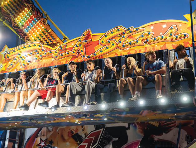 A group of people are riding a carousel at night. AI generated content