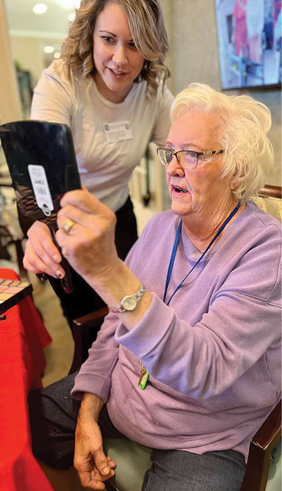 An elderly woman is holding a mirror while a younger woman looks on. AI generated content