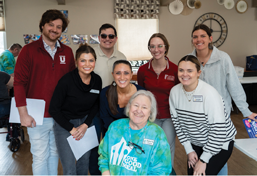 A group of people posing for a picture, including a woman in a blue shirt with the word “hope" on it. AI generated content