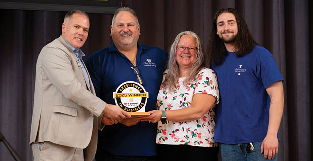 Four people are standing together, holding an award. AI generated content
