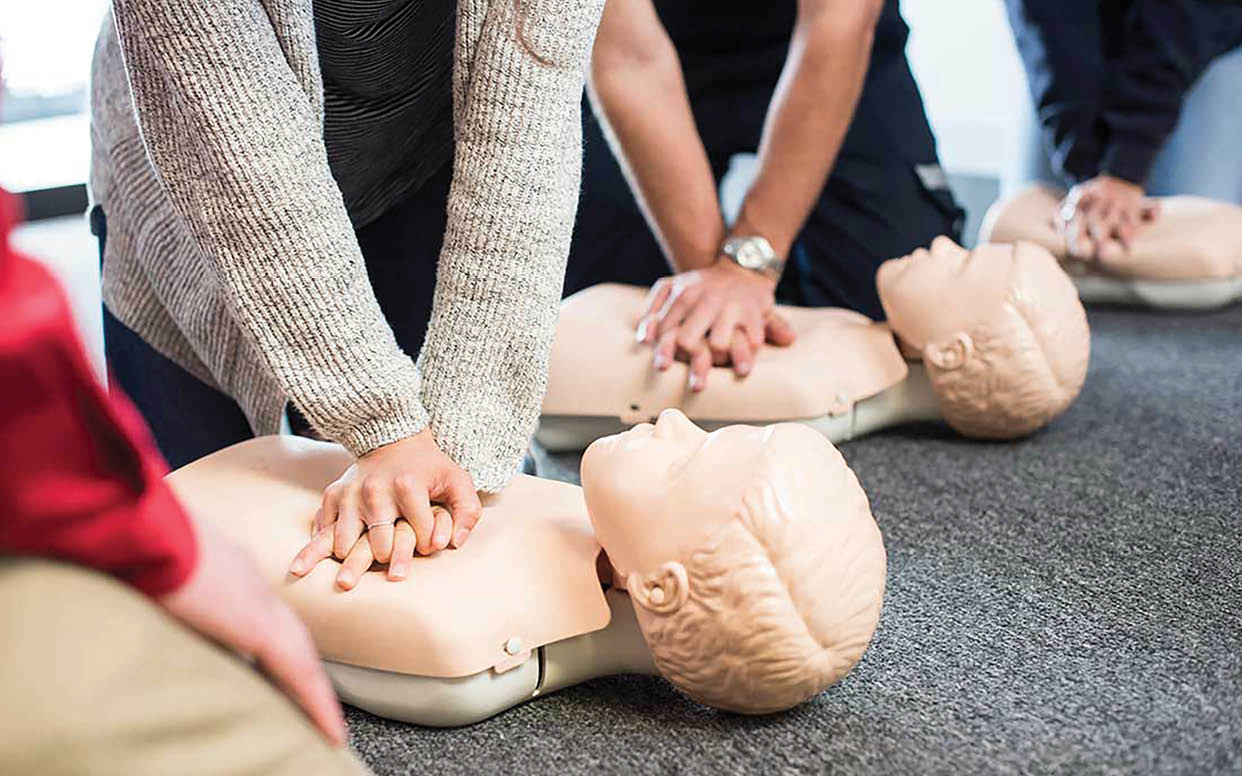 A group of people are practicing CPR on mannequins. AI generated content