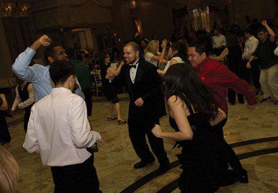 A group of people are dancing in a room, some wearing ties. AI generated content