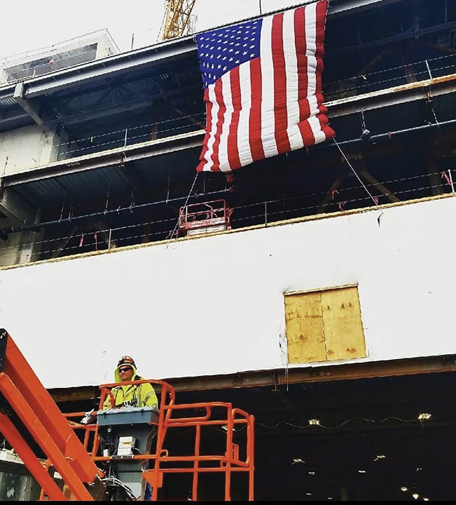 A man is standing on a platform, operating a machine to raise an American flag. AI generated content
