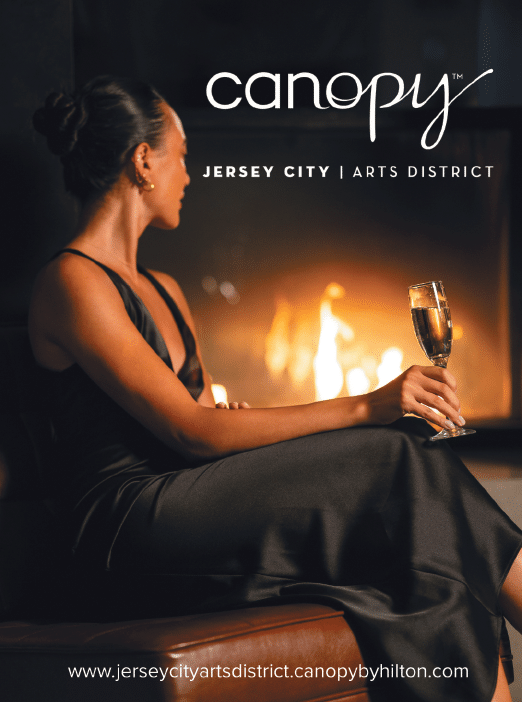 A woman in a black dress is sitting in front of a fireplace. She is holding a glass of wine. AI generated content