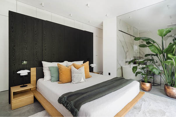 A bedroom with a bed, a nightstand, and a potted plant. The bed has a striped blanket and pillows. AI generated content