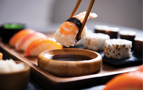 A wooden tray with sushi and seafood on it. AI generated content