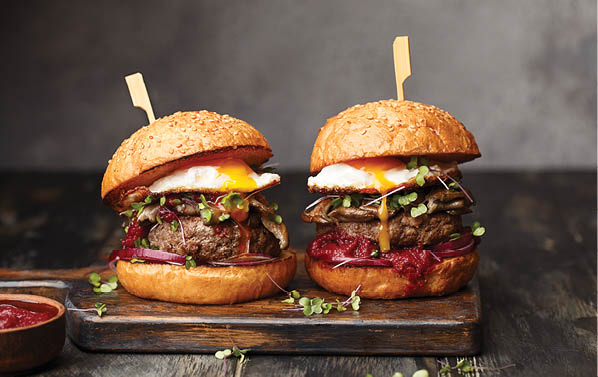 Two hamburgers with meat and vegetables on a wooden tray. AI generated content