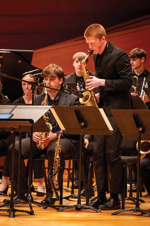 A group of people playing instruments. Description generated by AI