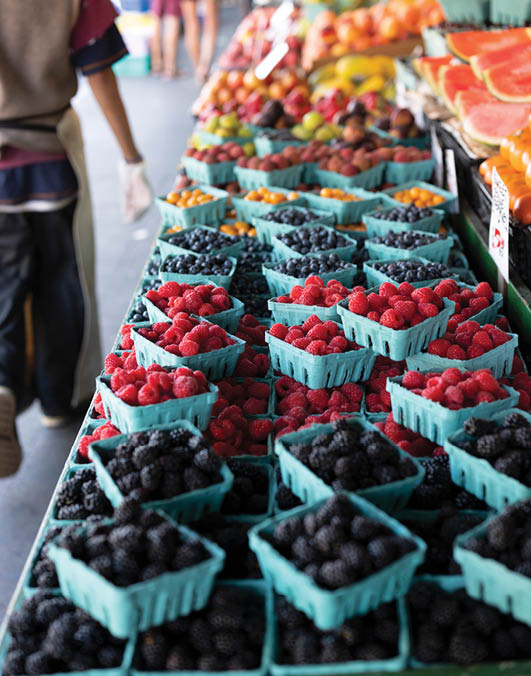 Fresh organic raspberries on stall for sell in marketplace