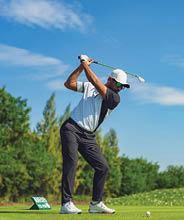Asian man golfing on the course in summer