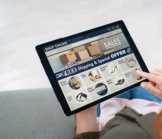 Back view of mature woman doing shopping online on website with digital tablet at home  Top view of woman with red hair relaxing on sofa while shopping online on ecommerce website  Rear view of girl hand touching screen while selecting product on e-commerce portal 