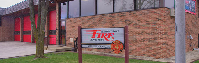 A red and white sign is in front of a brick building. Description generated by AI