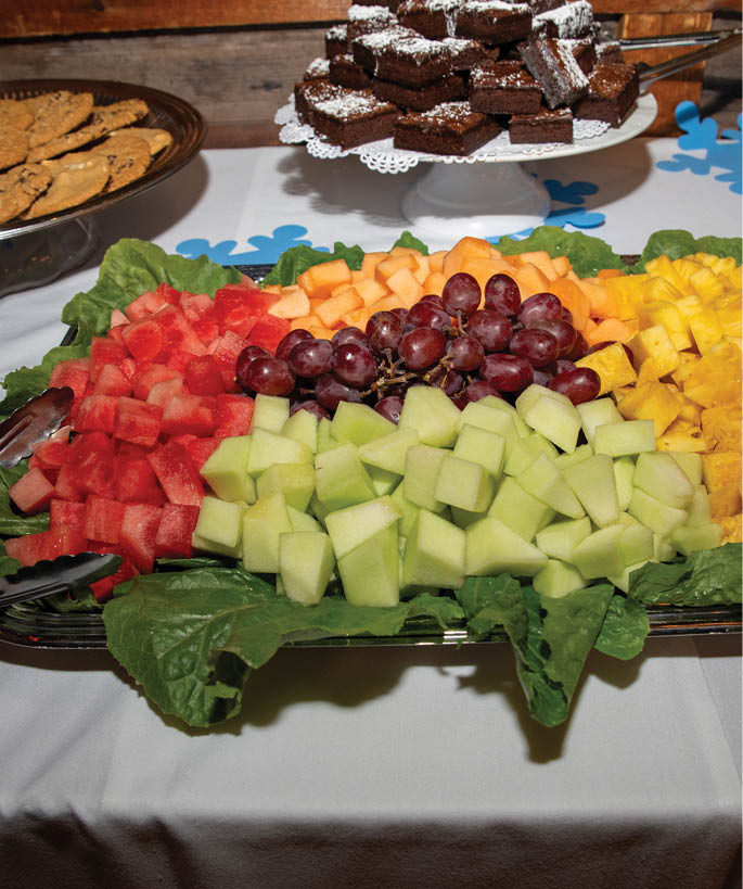 A white table with a tray of fruit and vegetables. Description generated by AI