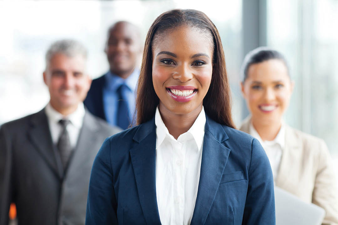pretty african american businesswoman standing in front of co-workers