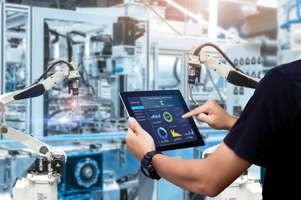 Smart industry control concept.Hands holding tablet on blurred automation machine as background