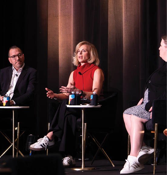 Four people are sitting on chairs on a stage, engaged in a discussion. AI generated content