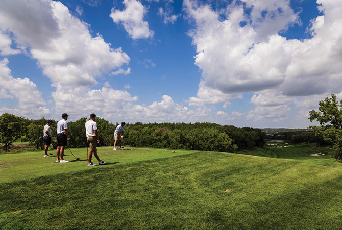 Four men are standing on a lush green golf course, preparing to play a game. AI generated content