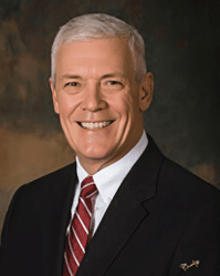 A man wearing a suit and tie with a red tie. Description generated by AI