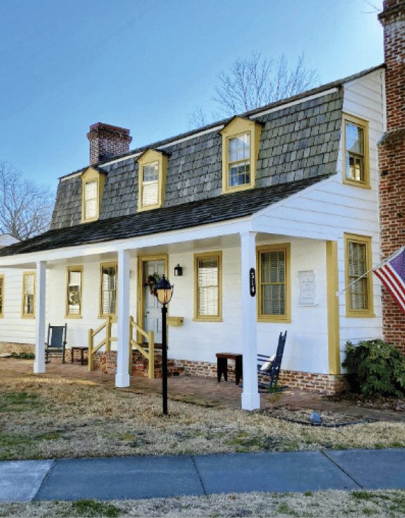 A white house with a flag on the front. Description generated by AI