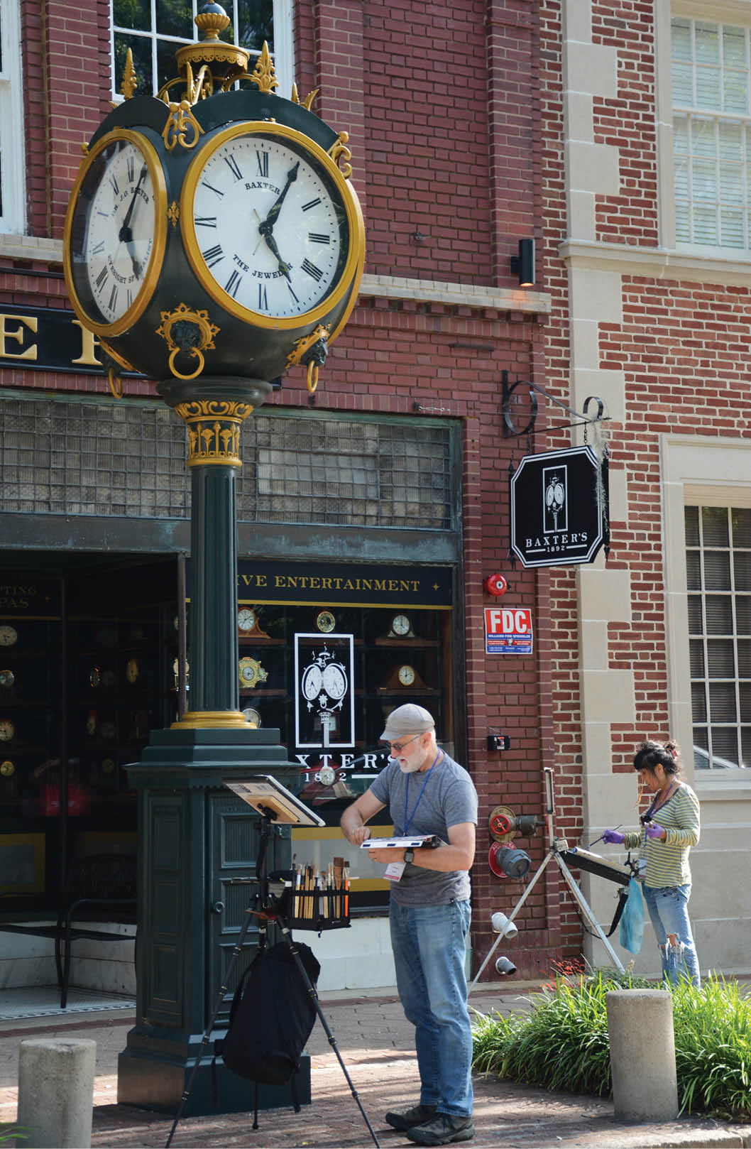 A man is painting a picture in front of a clock. Description generated by AI