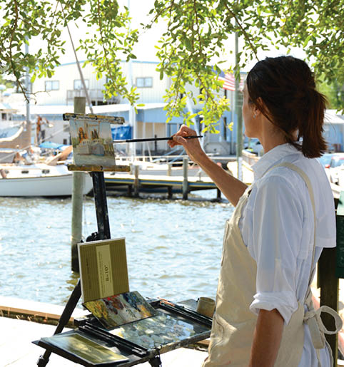 A woman is painting a picture of a boat. Description generated by AI