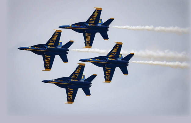 Four blue and yellow airplanes flying in formation. Description generated by AI