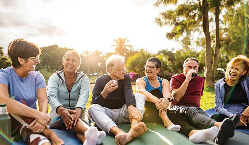 Happy multiracial senior friends drinking a tea after workout activities in a park