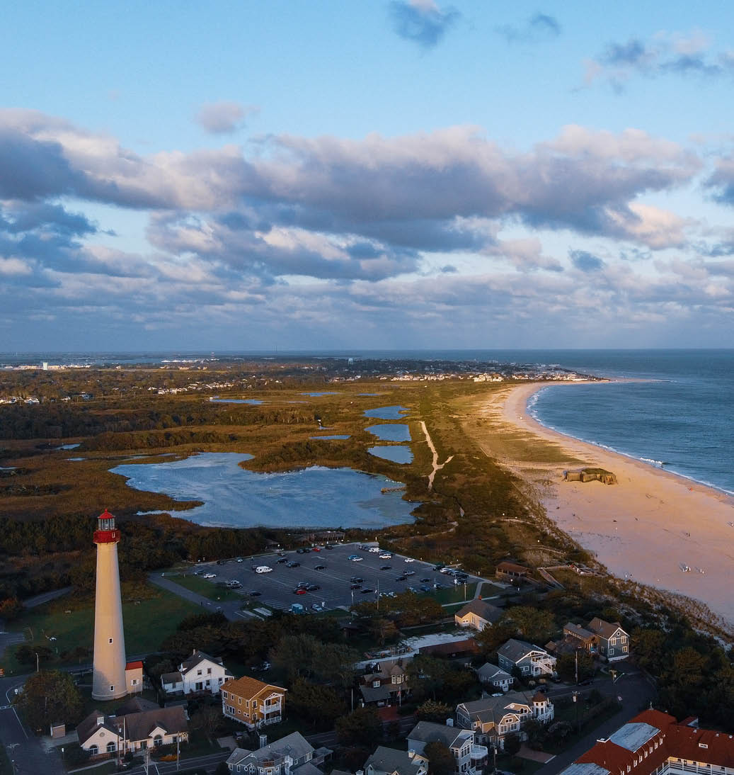 An aerial image showing the North most point of the tip of Cape May, NJ. It’s famous lighthouse, on the national historic register, looks out upon the deep blue Atlantic Ocean.