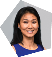 A woman wearing a purple shirt and earrings is smiling for the camera. AI generated content