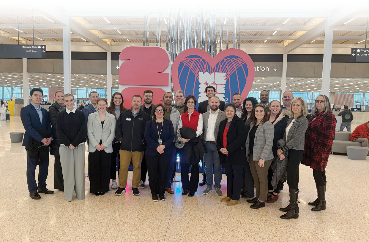 A group of people posing for a picture in an airport. AI generated content