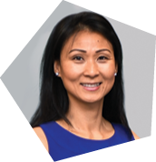 A woman wearing a purple shirt and earrings is smiling for the camera. AI generated content