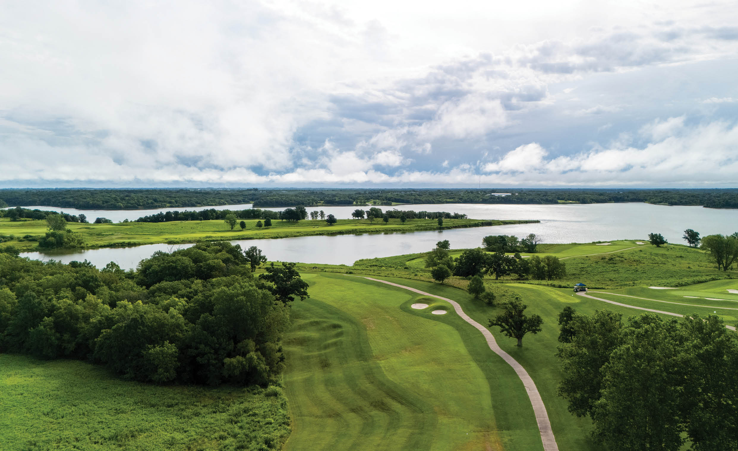A green golf course with a large body of water in the background. AI generated content