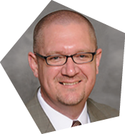 A man wearing glasses and a suit smiles for the camera. AI generated content