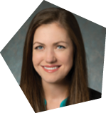 A woman wearing a green shirt and a black suit is smiling for the camera. AI generated content